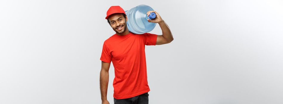 Delivery Concept - Handsome African American delivery man holding water tank. Isolated on Grey studio Background. Copy Space