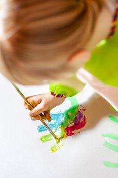 Little girl using watercolour at home during the pandemic lockdown.