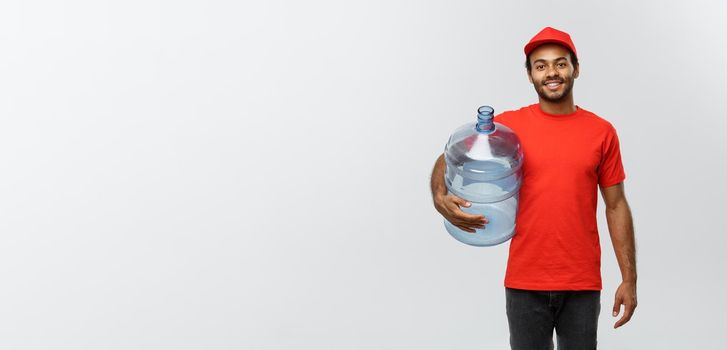 Delivery Concept - Handsome African American delivery man holding water tank. Isolated on Grey studio Background. Copy Space