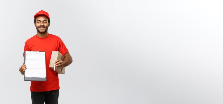 Delivery Concept - Portrait of Handsome African American delivery man or courier showing a confirmation document form to sign. Isolated on Grey studio Background. Copy Space