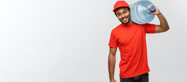 Delivery Concept - Handsome African American delivery man holding water tank. Isolated on Grey studio Background. Copy Space