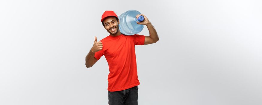 Delivery Concept - Handsome African American delivery man holding water tank. Isolated on Grey studio Background. Copy Space