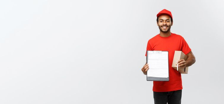 Delivery Concept - Portrait of Handsome African American delivery man or courier showing a confirmation document form to sign. Isolated on Grey studio Background. Copy Space