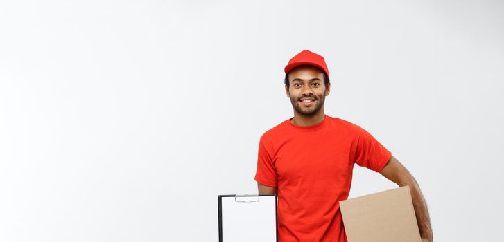 Delivery Concept - Portrait of Handsome African American delivery man or courier showing a confirmation document form to sign. Isolated on Grey studio Background. Copy Space