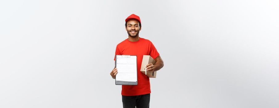 Delivery Concept - Portrait of Handsome African American delivery man or courier showing a confirmation document form to sign. Isolated on Grey studio Background. Copy Space