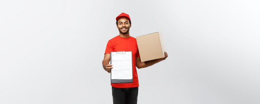 Delivery Concept - Portrait of Handsome African American delivery man or courier showing a confirmation document form to sign. Isolated on Grey studio Background. Copy Space