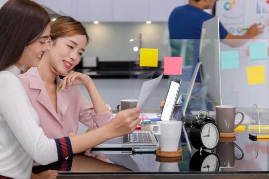 Asian Business Team Meeting Brainstorming Business start up working at Private Home Office social distancing among Coronavirus outbreak New generation business people meeting analysis work from laptop