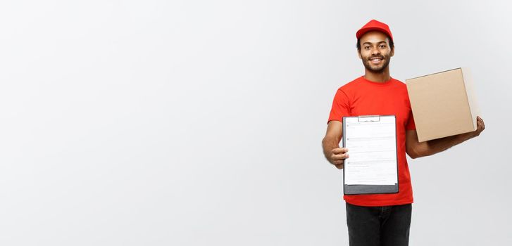 Delivery Concept - Portrait of Handsome African American delivery man or courier showing a confirmation document form to sign. Isolated on Grey studio Background. Copy Space