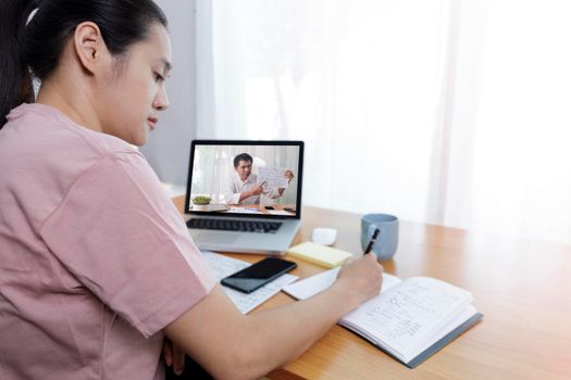 rear angle view of video conference with teacher on laptop at home. Top view businesswomen using laptop meeting with colleagues. Covid-19 work from home.,  e-learning education concept.