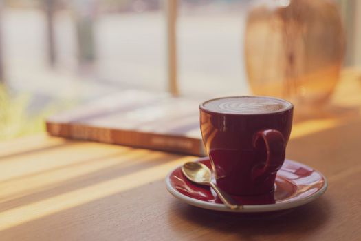 Close up hot art Latte, cappuccino Coffee in red cup on wooden table in Coffee shop blur background with bokeh image process with vintage style