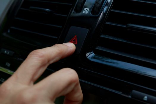 Close up hand press the emergency light in the car, Fingers press button.for open the contract emergency light in car. Emergency button press for open emergency light warning sign symbol out side car