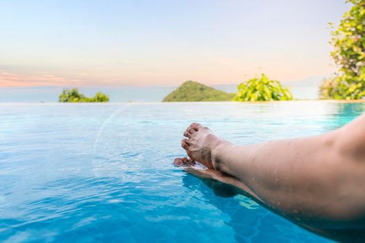Close up and select legs.  Women lifestyle relaxing and happy in luxury infinity pool outdoor, summer time at resort in the hotel. Summer holiday and Vacations concept. with copy space