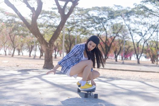 Young asian women play surf skate board at park skate ramp outdoors on morning. Happy women play surfskate board at park . Sport activity lifestyle concept