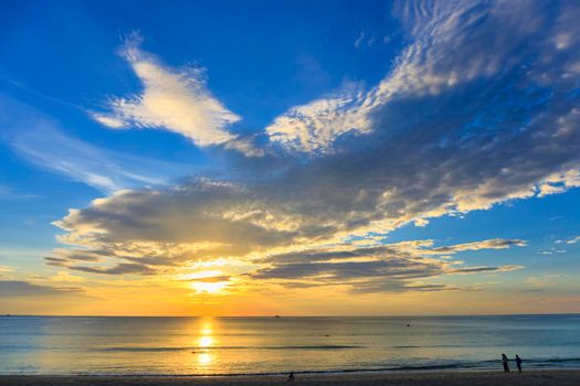 Beautiful sunset over the clam sea with cloud and sky background. Sunset over tropical beach. Nature summer  concept. Peak sunset over sea with yellow light reflect in cloud.
