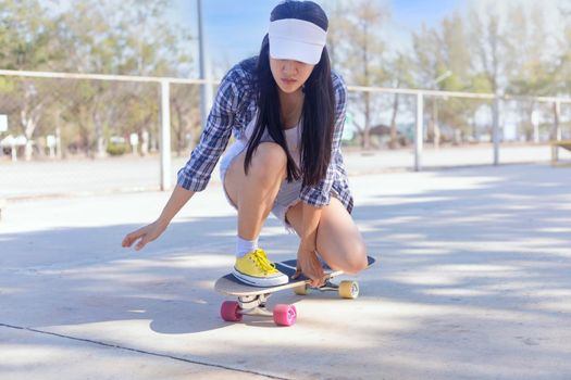 Young asian women play surf skate board at park skate ramp outdoors on morning. Happy women play surfskate board at park . Sport activity lifestyle concept
