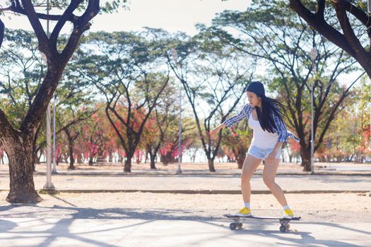 Young asian women play surf skate board at park skate ramp outdoors on morning. Happy women play surfskate board at park . Sport activity lifestyle concept