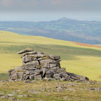 One of the Great Staple Tor rock pillars overlooking St Michael de Rupe church on Brent Tor, Dartmoor National Park, Devon, UK