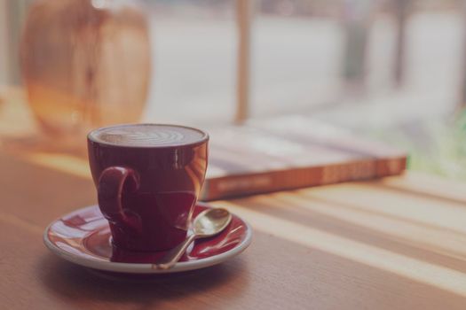 Close up hot art Latte, cappuccino Coffee in red cup on wooden table in Coffee shop blur background with bokeh image process with vintage style