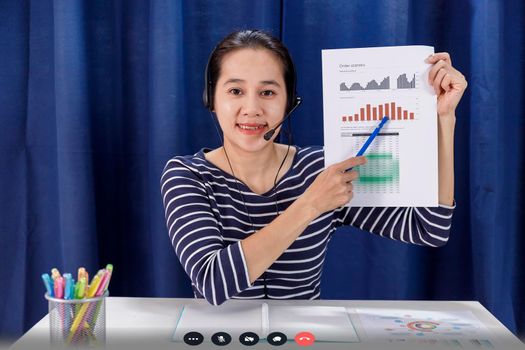 Screen of Businesswomen sit at desk and talk with business colleague via internet shows a graph with the dynamics of economic growth and analysis with team. Covid-19 work from home concept