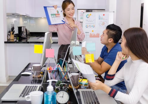 Asian small business start up working at Private Home Office social distancing covid-19 outbreak . Business people show and talking about document chart financial report. Start up teamwork brainstorm