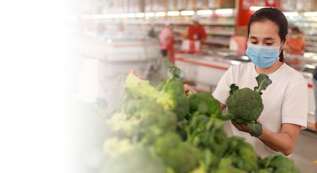 Asian woman long hair wearing protective face mask  in supermarket department store. Female, looking grocery to buy  some fruit. New normal after covid-19. Family concept. with copy space banner