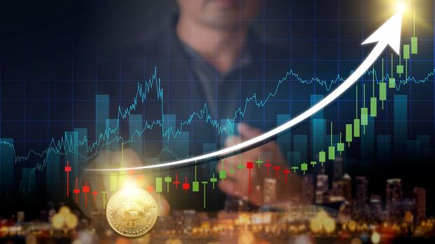 Hands of businessman with gold bitcoin coin. Volatile business graph on global network, Financial, Stock market, Cryptocurrency and investment. Stock market graph up. New Virtual money concept