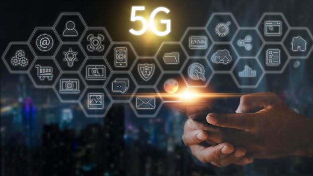 Hand of business man hold mobilephone connect network 5G with icon concept, technology network wireless systems and internet of things, new technologies coming up in the future. Network connection 5G