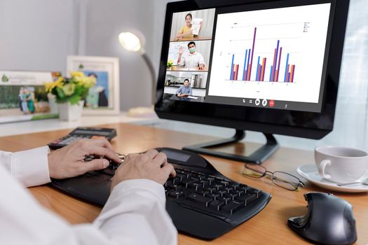 Hand of businessman and businesswoman analysis financial chart with videoconference online meeting. Hand of businesswomen using laptop meeting with diverse colleagues. Covid-19 working from home. 