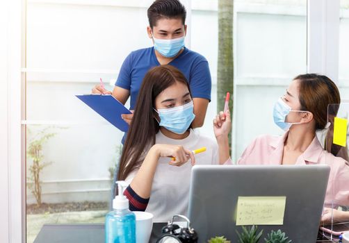 Asian Business Team Meeting Brainstorming. Business start up working at Private Home Office social distancing among Coronavirus outbreak. new generation business people meeting analysis work from laptop