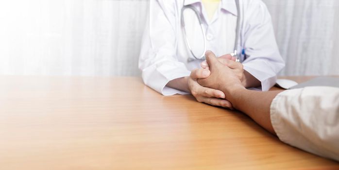 Doctor working in her clinic and listening to the patient, Doctor hold hand of patient and listening explaining his symptoms. healtcare and assistance concept