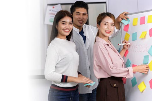 Business Team brainstorm meeting. Group of business people working at Private Home Office. Business team using post-it paper on whiteboard. business women writing SUCCESS on white board