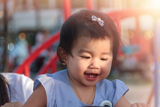 Portrait of smiling happy little girl enjoy with playground outdoor. Child playing on outdoor playground. Asian little girl play at outdoor playground.