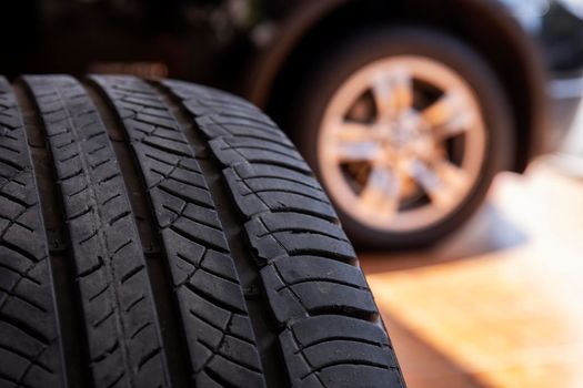 Close up of old tire with car wheel background. Tire workshop and change old wheel on the car. Used car tires stacked in piles at tire fitting service repair shop