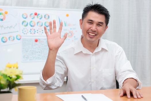 Asian businessman sitting at home office look at camera doing online work interview during vide conference chat. Webcam view. Business people using video call contact with friend, customers, partners from home