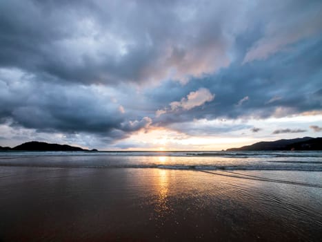 Beautiful sunset over the calm sea with cloud and sky background. Sunset over tropical beach. Nature summer  concept. Peak sunset over sea with yellow light reflect in cloud