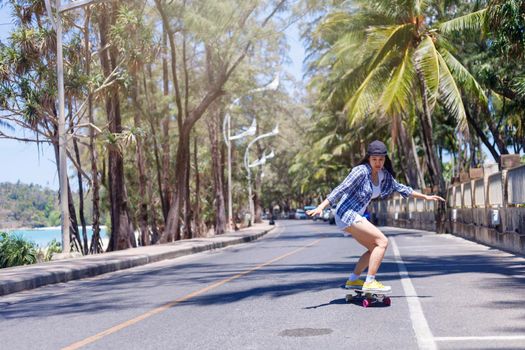 Young asian women play surf skate board at beach road outdoors on morning. Happy women play surfskate board on beach road . Sport activity lifestyle concept