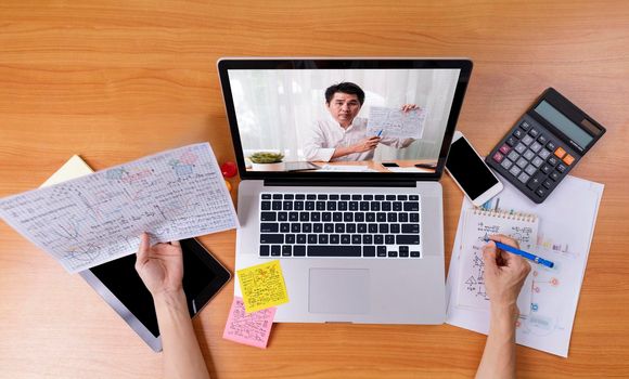High angle view of video conference with teacher on laptop at home. Top view businesswomen using laptop meeting with colleagues. Covid-19 work from home.,  e-learning education concept.