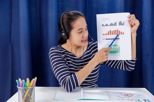 Screen of Businesswomen sit at desk and talk with business colleague via internet shows a graph with the dynamics of economic growth and analysis with team. Covid-19 work from home concept