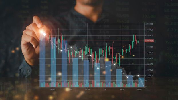 Businessman writing analyze graph for trade stock market on the screen. Businessman hand drawing chart graph stock of growth. Hand man uses pen to draw stock graph chart point of target success.