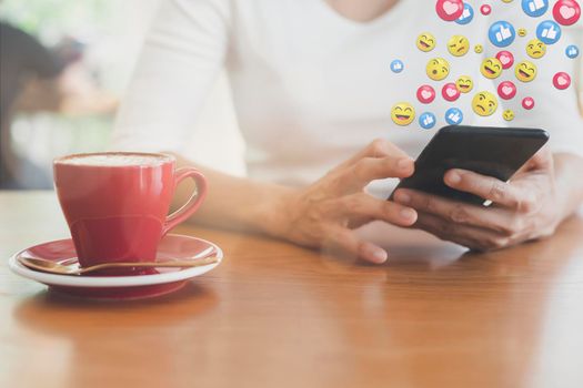 Asian woman sitting in coffeeshop relaxing with cell phone. young woman relax with social media only. women using the smart phone holding and typing with others through emoji and text online.