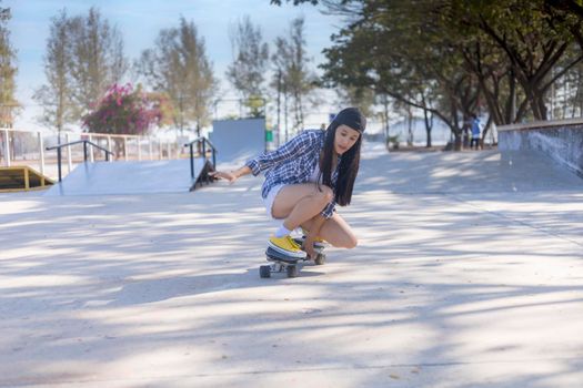 Young asian women play surf skate board at park skate ramp outdoors on morning. Happy women play surfskate board at park . Sport activity lifestyle concept