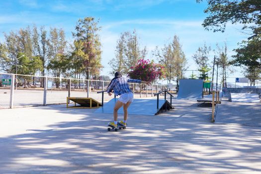 Young asian women play surf skate board at park skate ramp outdoors on morning. Happy women play surfskate board at park . Sport activity lifestyle concept