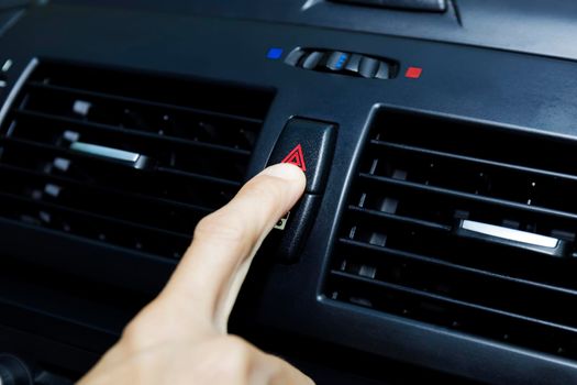 Close up hand press the emergency light in the car, Fingers press button.for open the contract emergency light in car. Emergency button press for open emergency light warning sign symbol out side car