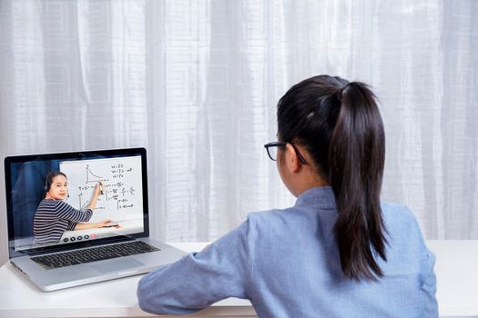 Asian little girl student learning via internet online class from school teacher duling covid-19 outbreak. Man teaching math by whiteboard. Homeschool learn from home concept