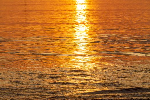 Golden sunset light reflection in sea water, Abstract background with sunlight effect in beautiful romantic and dreamy golden tones