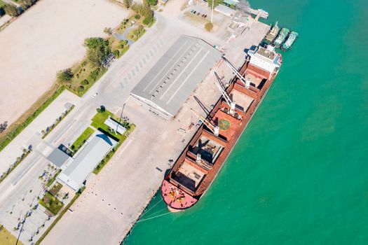 Aerial drone top view of containers cargo ship at industrial import-export port. Business logistic import and export freight transportation by container ship in open sea