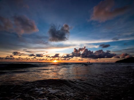 Beautiful sunset over the calm sea with cloud sky background. Sunset over tropical beach. Nature summer  concept. Peak sunset over sea with yellow light reflect on sea water. Tranquil seascape.