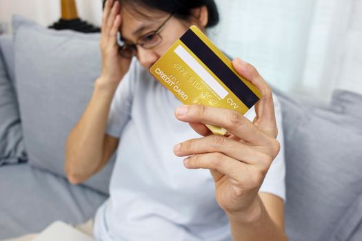 Close up hand of women hold credit card feeling stressed unhappy and worry about receipt tax debt payment burden of over shopping problem from shopping online.
