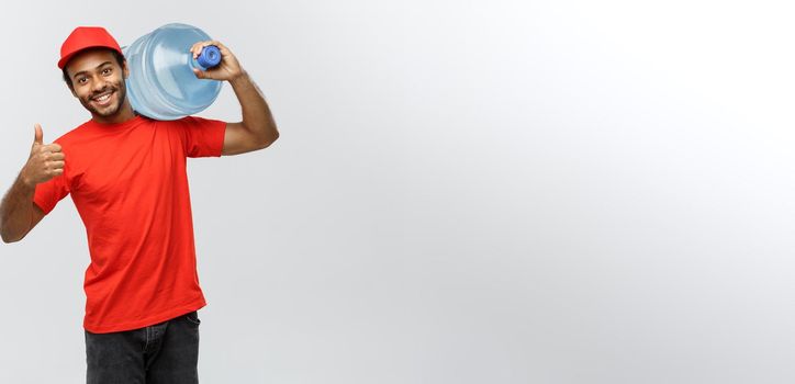 Delivery Concept - Handsome African American delivery man holding water tank. Isolated on Grey studio Background. Copy Space