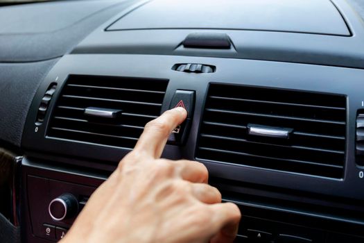Close up hand press the emergency light in the car, Fingers press button.for open the contract emergency light in car. Emergency button press for open emergency light warning sign symbol out side car